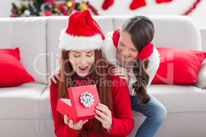 Festive mother and daughter with a christmas gift