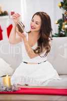 Smiling brunette holding  baby shoes at christmas