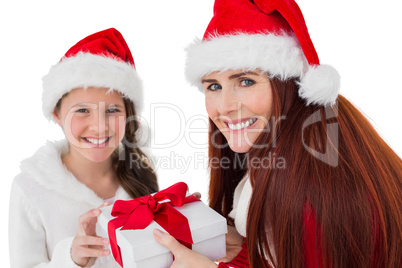 Festive mother giving daughter a gift