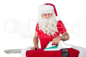 Happy santa claus ironing his jacket