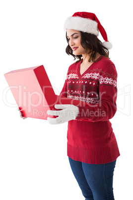 Festive brunette in winter clothes opening gift