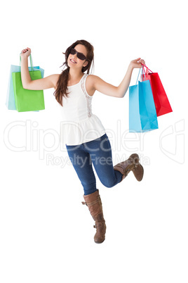 Happy brunette with sunglasses holding shopping bags