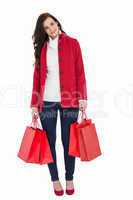 Smiling brunette in winter clothes holding shopping bags