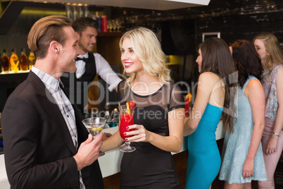 Attractive friends drinking cocktails together