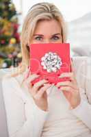 Blonde showing gift on the couch at christmas