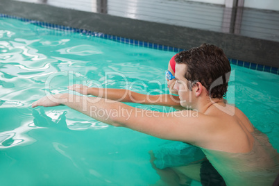 Cute little boy learning to swim with coach