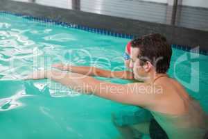 Cute little boy learning to swim with coach