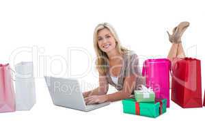Happy blonde shopping online with laptop