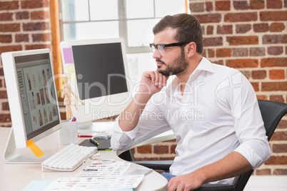 Concentrated male photo editor using computer in office Concentrated male photo editor using computer in office