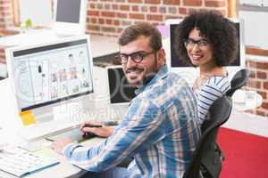 Smiling photo editors using digitizer in office