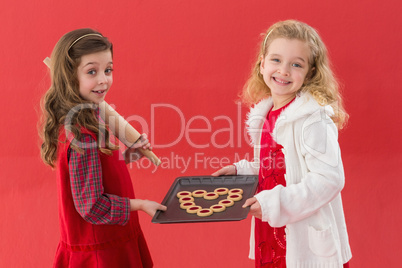 Festive little girls holding cookies