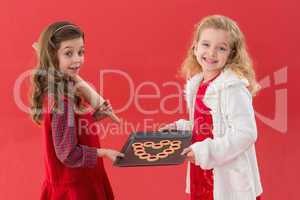 Festive little girls holding cookies