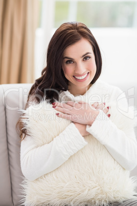 Smiling brunette holding a cushion