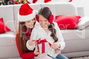 Festive mother and daughter with a christmas gift