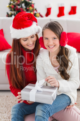 Festive mother and daughter opening a christmas gift