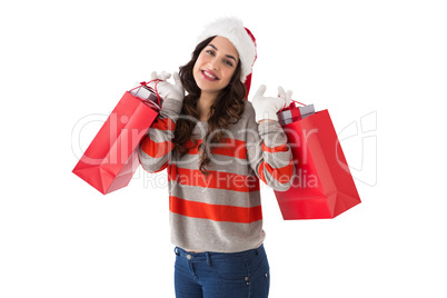 Cheerful brunette holding shopping bags full of gifts