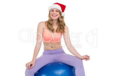 Smiling blonde woman sitting on exercise ball