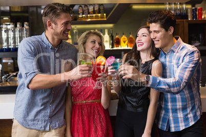 Happy friends drinking cocktails together