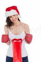 Festive brunette in boxing gloves opening shopping bag