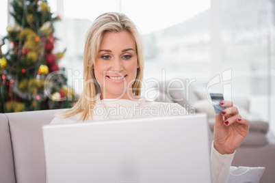 Blonde shopping online on the couch at christmas