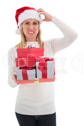 Stressed blonde in santa hat holding gifts