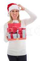 Stressed blonde in santa hat holding gifts