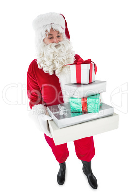 Santa claus holding pile of gifts