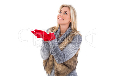 Blonde in winter clothes with hands out