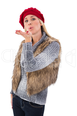 Blonde in winter clothes blowing kiss