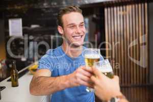 Young man toasting with pint of beer