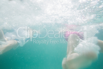 Cute kids swimming underwater in pool