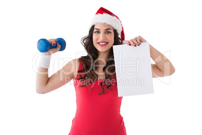 Festive fit brunette showing page and dumbbell