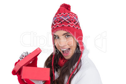 Excited brunette opening a christmas gift