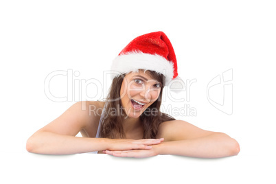 Festive brunette leaning on large poster