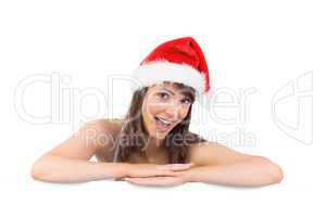 Festive brunette leaning on large poster