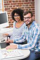 Smiling photo editors using digitizer in office