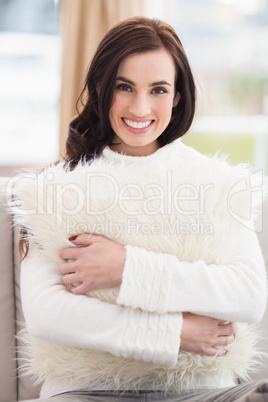 Pretty brunette holding a cushion