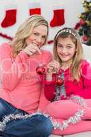 Festive mother and daughter smiling at camera