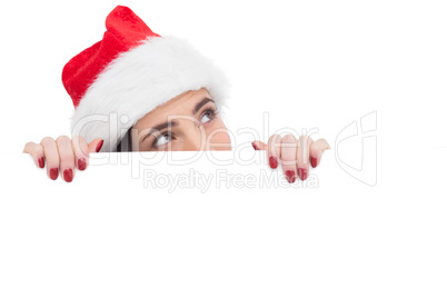 Pretty brunette in santa hat showing white poster