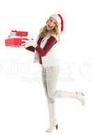 Smiling blonde in warm clothing holding pile of gifts