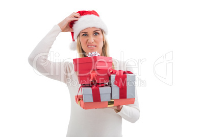 Confused blonde in santa hat holding gifts