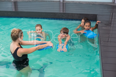 Cute swimming class in pool with coach