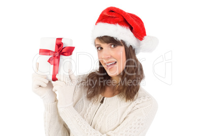 Festive brunette showing a gift