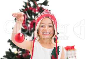 Festive little girl holding christmas bauble