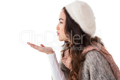 Brunette in winter clothes blowing kiss