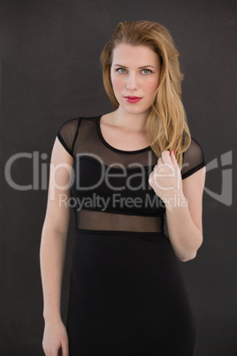 Pretty blonde wearing sexy black dress posing