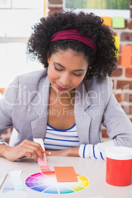 Female designer with color samples at desk