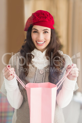 Happy brunette opening gift bag