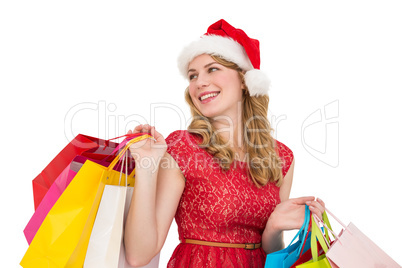 Smiling blonde in santa hat holding shopping bags