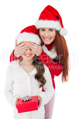 Festive mother surprising daughter with gift